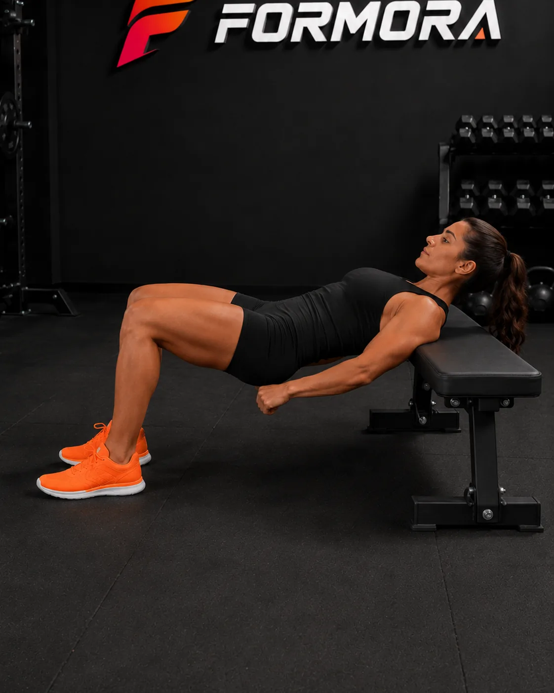 Hip Thrust form odağı: üstte pelvis ve kaburga kontrolü korunurken kalça güçlü biçimde uzatılmış.